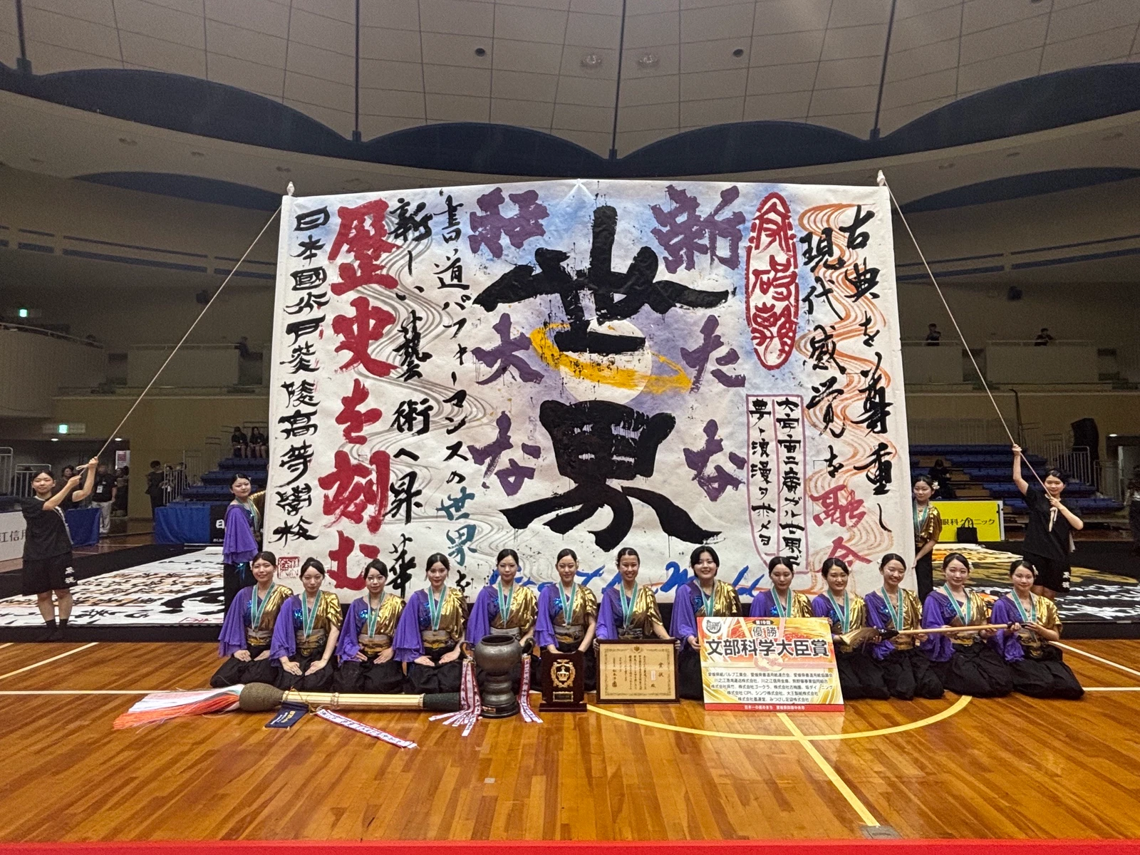 大きな書道作品を囲む水戸葵陵高校の皆さん